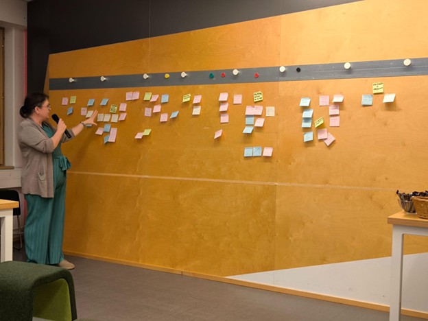 person presenting, post it notes on wall.