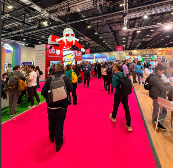 Many people walking around the exhibition hall. 